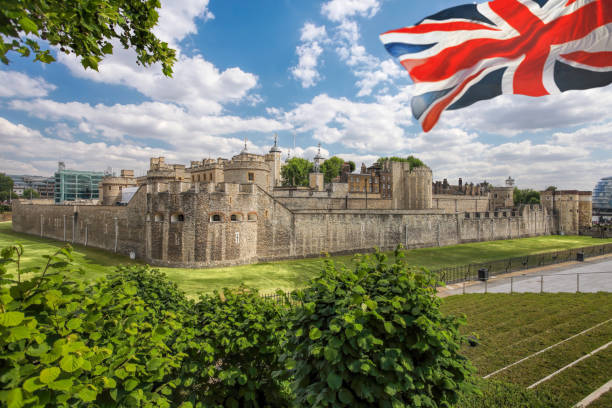 tower of london with flag of england in london, tower hill, uk - local landmark international landmark middle ages tower of london imagens e fotografias de stock