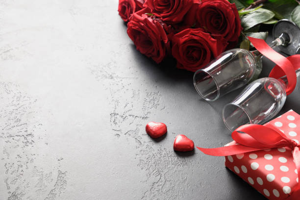 istock Valentine's day greeting card with red roses and gift on black. 1300136641