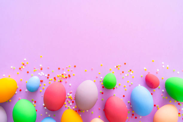 istock Colorful Easter eggs with sugar sprinkles on purple colored background. Copy space 1300137162