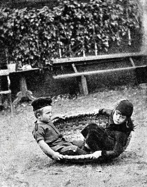 istock Children playing, boy and girl swinging in a basket 1300138054