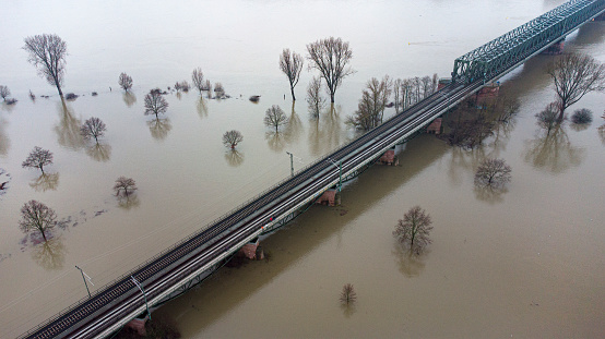Flooded river banks at Rhine River and Main River, Germany after heavy rainfall - aerial view of railroad track