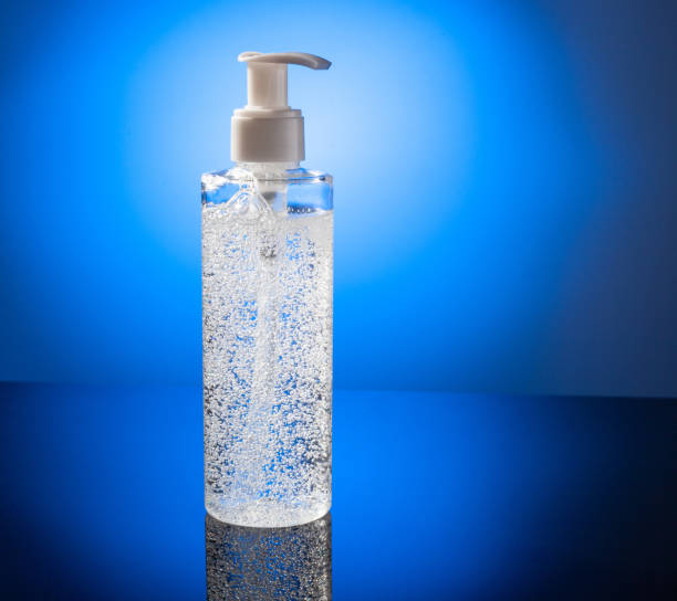 istock Cosmetic product for makeup remover. Clear liquid with small air bubbles on blue backgroud. Bottle with dispenser. 1300140049