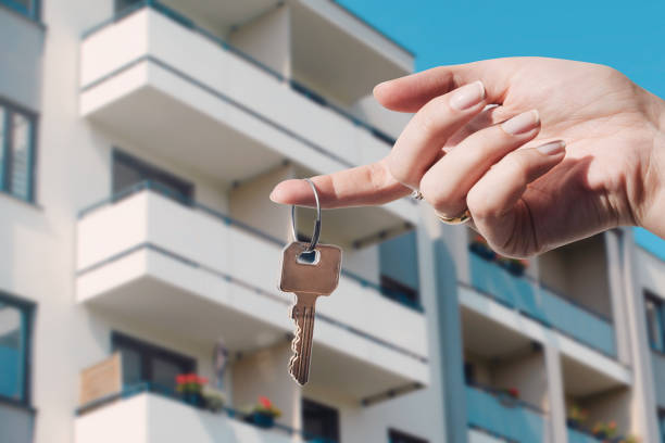 agent immobilier retenant des clefs au nouvel appartement - bien immobilier commercial photos et images de collection
