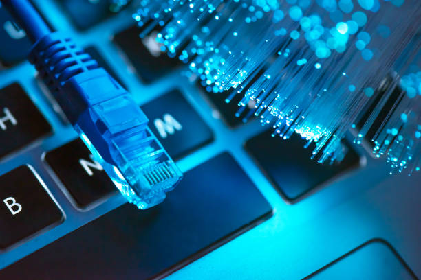 High speed fiber optic internet concept Internet cable, RJ-45 plug on laptop keyboard. High speed fiber optic internet concept bandwidth stock pictures, royalty-free photos & images