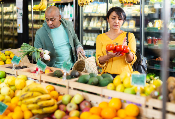 istock Married couple choosing tomatoes at grocery store 1300141857