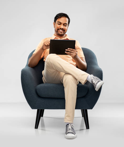 istock happy indian man with tablet pc computer in chair 1300142695