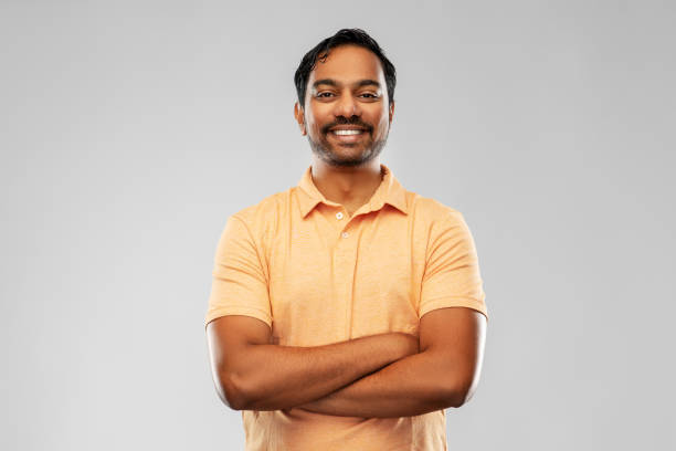 portrait of happy smiling young indian man people and furniture concept - portrait of happy smiling young indian man with crossed arms over grey background isolated color stock pictures, royalty-free photos & images
