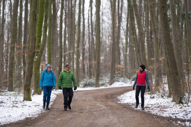 istock happy people walking together through forest in winter keeping proper distance 1300143992