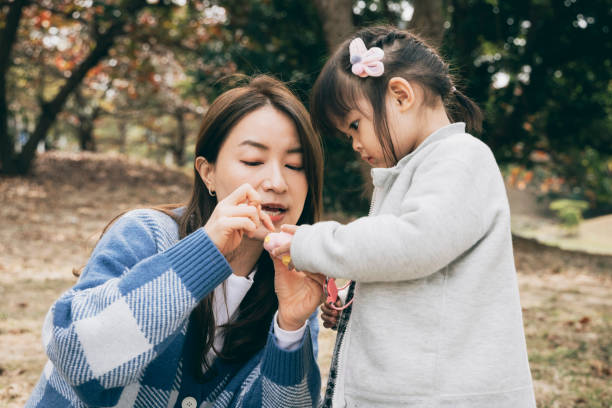 istock Mother teaching daughter to use toy camera 1300144922