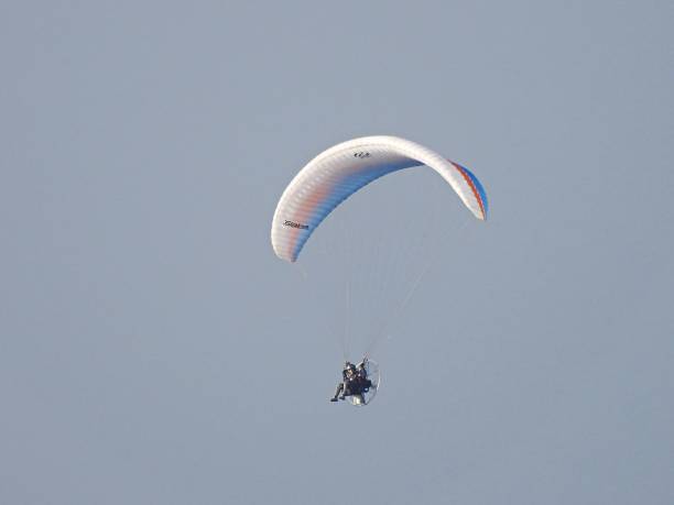 Two paraglider on blue sky.