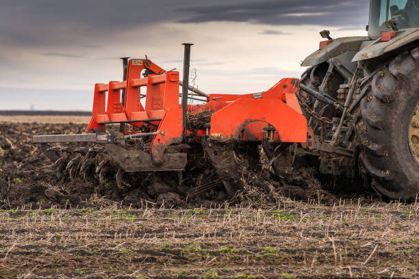 istock tractor plows the field in the evening at sunset. 1300149627