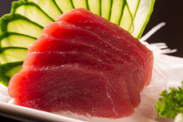 istock sashimi with tuna in a white plate. On a black background. 1300151208
