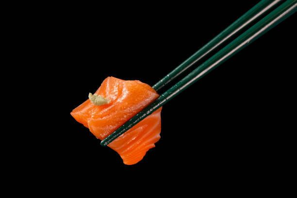 istock Hashi hold sushi and rolls isolated over black background 1300151626