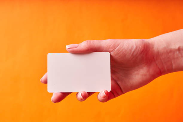 istock A woman's hand holds a white plastic card. Isolated card in hand 1300151877