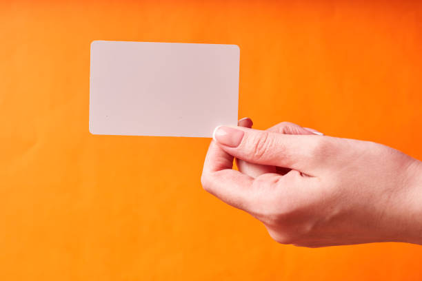 istock A woman's hand holds a white plastic card. Isolated card in hand 1300151897