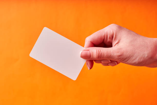 istock A woman's hand holds a white plastic card. Isolated card in hand 1300152416