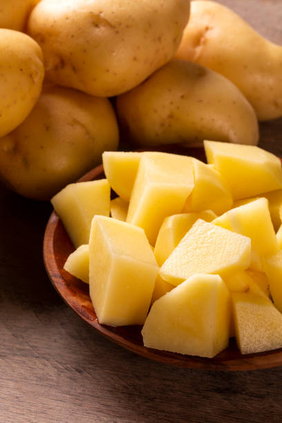 istock Potatoes and potato sliced on wooden table. Selective focus 1300154485