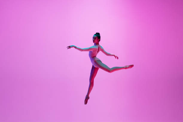 istock Young and graceful ballet dancer isolated on pink studio background in neon light. Art, motion, action, flexibility, inspiration concept. 1300154746