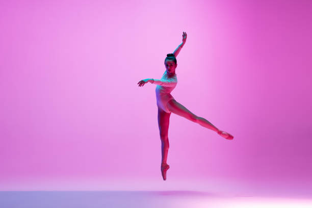 istock Young and graceful ballet dancer isolated on pink studio background in neon light. Art, motion, action, flexibility, inspiration concept. 1300154762