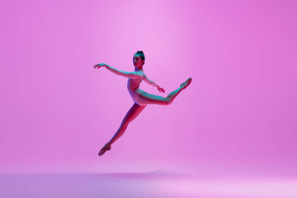 istock Young and graceful ballet dancer isolated on pink studio background in neon light. Art, motion, action, flexibility, inspiration concept. 1300154782
