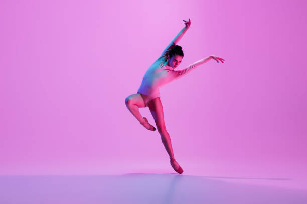 istock Young and graceful ballet dancer isolated on pink studio background in neon light. Art, motion, action, flexibility, inspiration concept. 1300154798