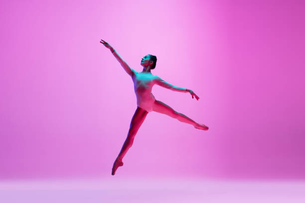 istock Young and graceful ballet dancer isolated on pink studio background in neon light. Art, motion, action, flexibility, inspiration concept. 1300154849