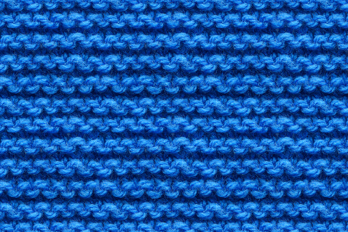 Blue Knitwear Fabric Texture. Machine Knitting Texture Macro Snapshot. Dark Blue Knitted Background.