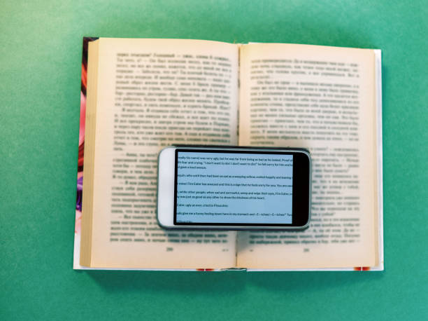 There is a cell phone on the open book. A New Reality. Selective Focus