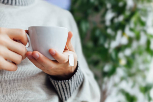 istock Man Holding A Cup Of Tea With Copy Space 1300158103