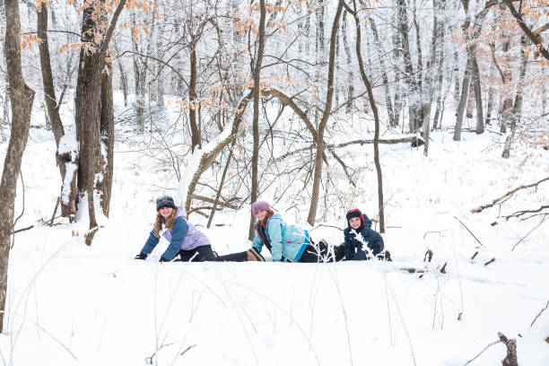 istock Three Children Crawling Through Snow in Woods 1300159846