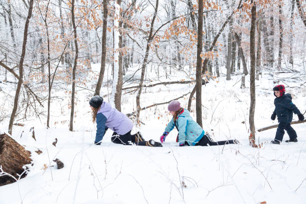 istock Three Children Playing In Snow in Woods 1300161027