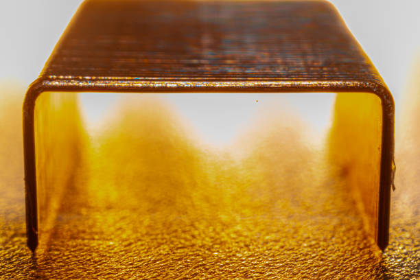 Coppered staples photographed close-up in brown tones. Group of copper staples placed as if it were a tunnel with the light coming from behind.