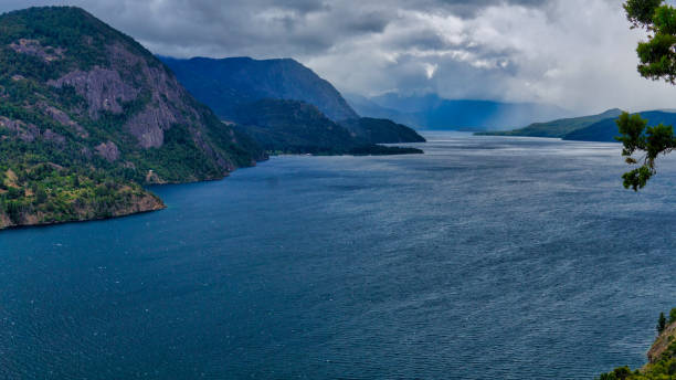 Landscape of lake Lacar Landscape of lake Lacar on a stormy afternoon. San Martin de los Andes, Neuquen, patagonia. Taken from the top of a hill looking to the large and a few mountains behind under a clouded sky. Shooted on a cold summer afternoon lácar lake photos stock pictures, royalty-free photos & images