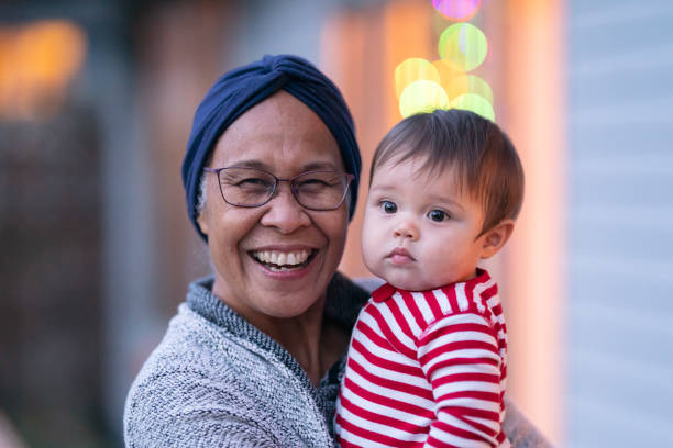 bella nonna etnica con il cancro che tiene in braccio sua nipote - cancer chemotherapy drug baby family foto e immagini stock
