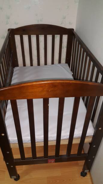 istock Crib by armchair at home 1300163072