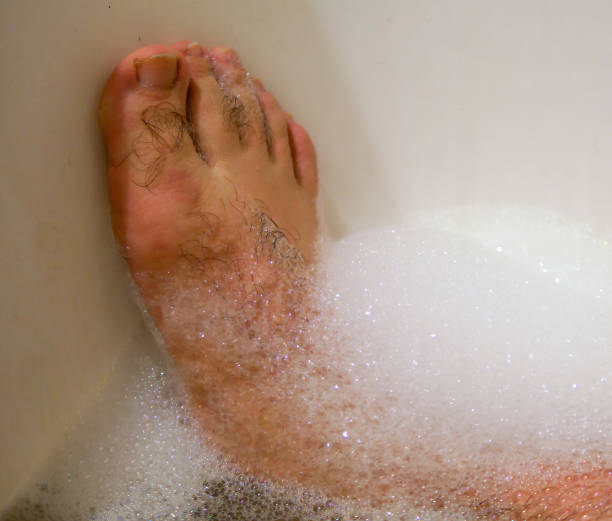 istock Man soaking his feet in a bath tub 1300164792