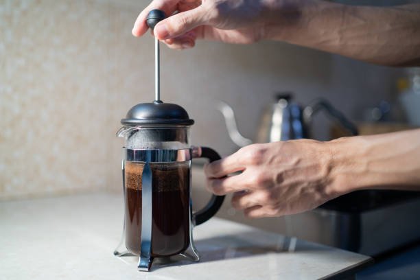 Making French Press coffee in the kitchen Making French Press coffee in the kitchen steep stock pictures, royalty-free photos & images