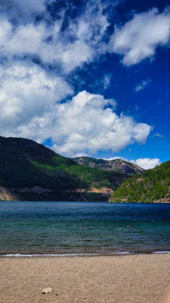 Lake Lacar Landscape of lake Lacar and a few green hills behind, San martin de los Andes, Neuquen, Argentina. Taken on a warm summer afternoon under a ble sky with a few white clouds from the beach lácar lake photos stock pictures, royalty-free photos & images