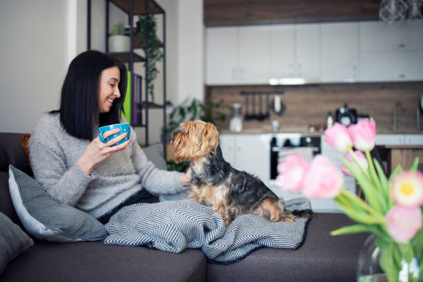 istock Young woman having a cup of coffee while cuddling her dog. 1300165134