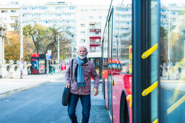 istock Handsome smiling senior man getting into bus. 1300168365