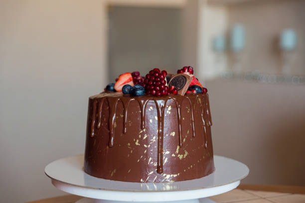 istock chocolate cake decorated with strawberries, blueberries and a pomegranate on an light background 1300168980