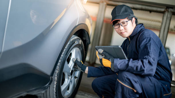 istock Asian auto mechanic checking the car wheel using tablet 1300169068