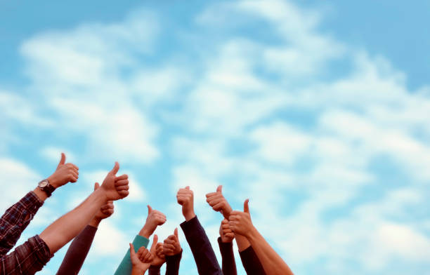 istock Group of people thumbs up blue sky. 1300170416