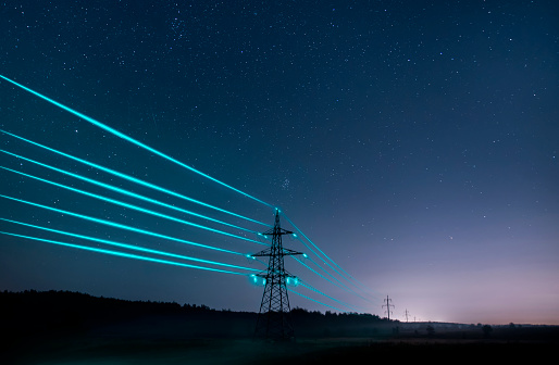Torres de transmisión de electricidad con cables brillantes contra el cielo estrellado. photo