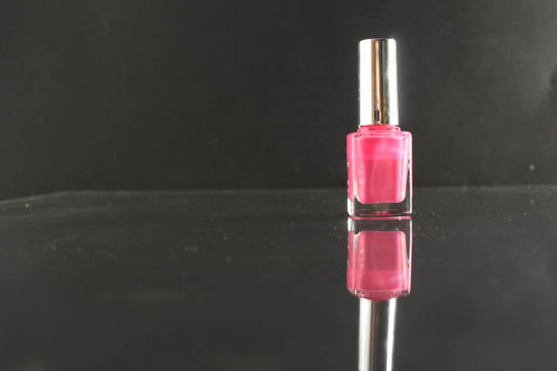 istock Bottle bottle with pink nail polish stands on a black background with a copyspace 1300176436