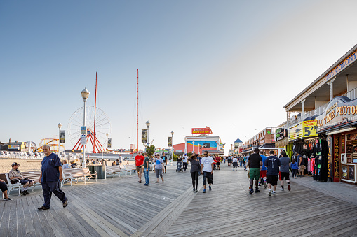Ocean City, MD/USA - October 6, 2018: Pedestrians stroll on the boardwalk lined with shops, restaurants and tourists attractions on the East Coast beach town of Ocean City, MD in autumn