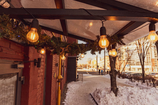 istock Cafe canopy is decorated with pine branches, Edison bulbs and shines with a warm yellow light 1300179182