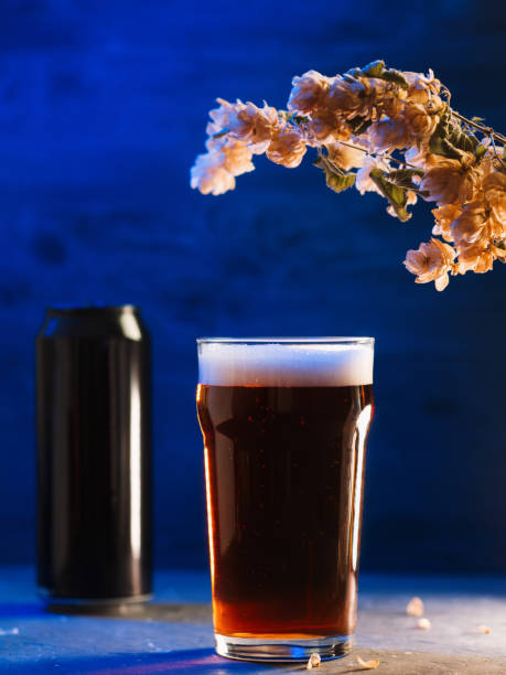 istock Craft light beer glass, beer bottle, dry hops, modern neon illuminated dark background 1300179388