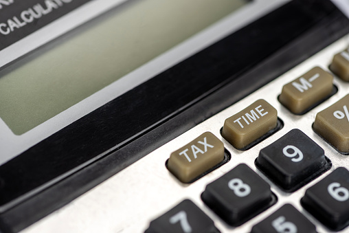 Word TAX TIME on calculator button. Business and tax concept.