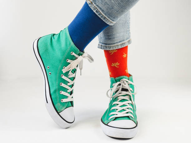 istock Green sneakers and funny socks on a white background 1300180726